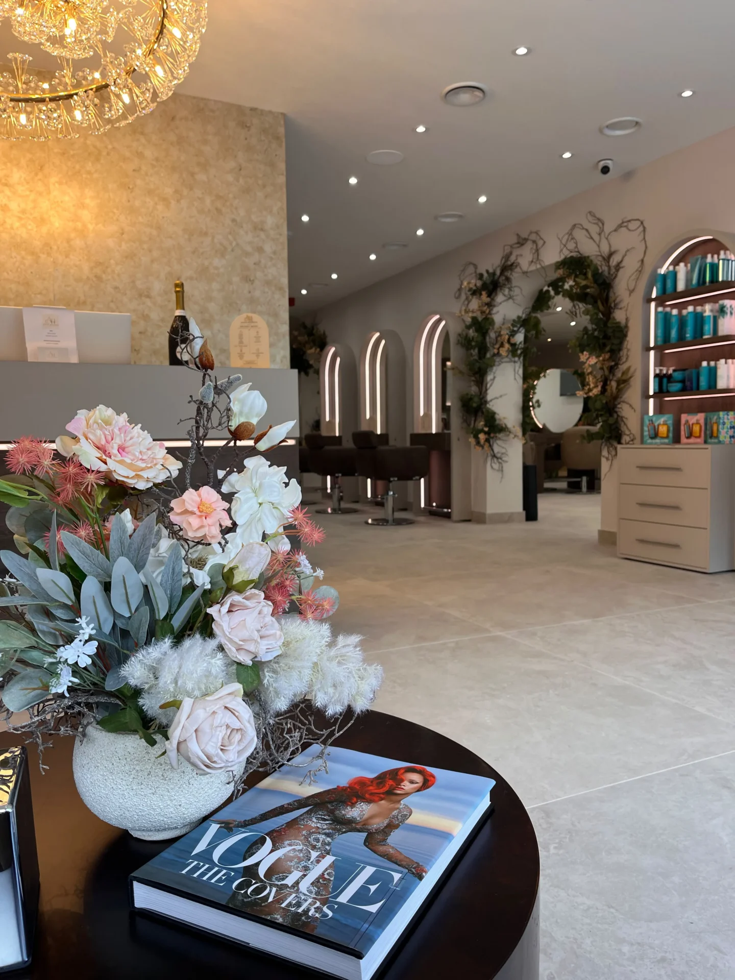 Salon with a table in the center, adorned with a vase of flowers and a book