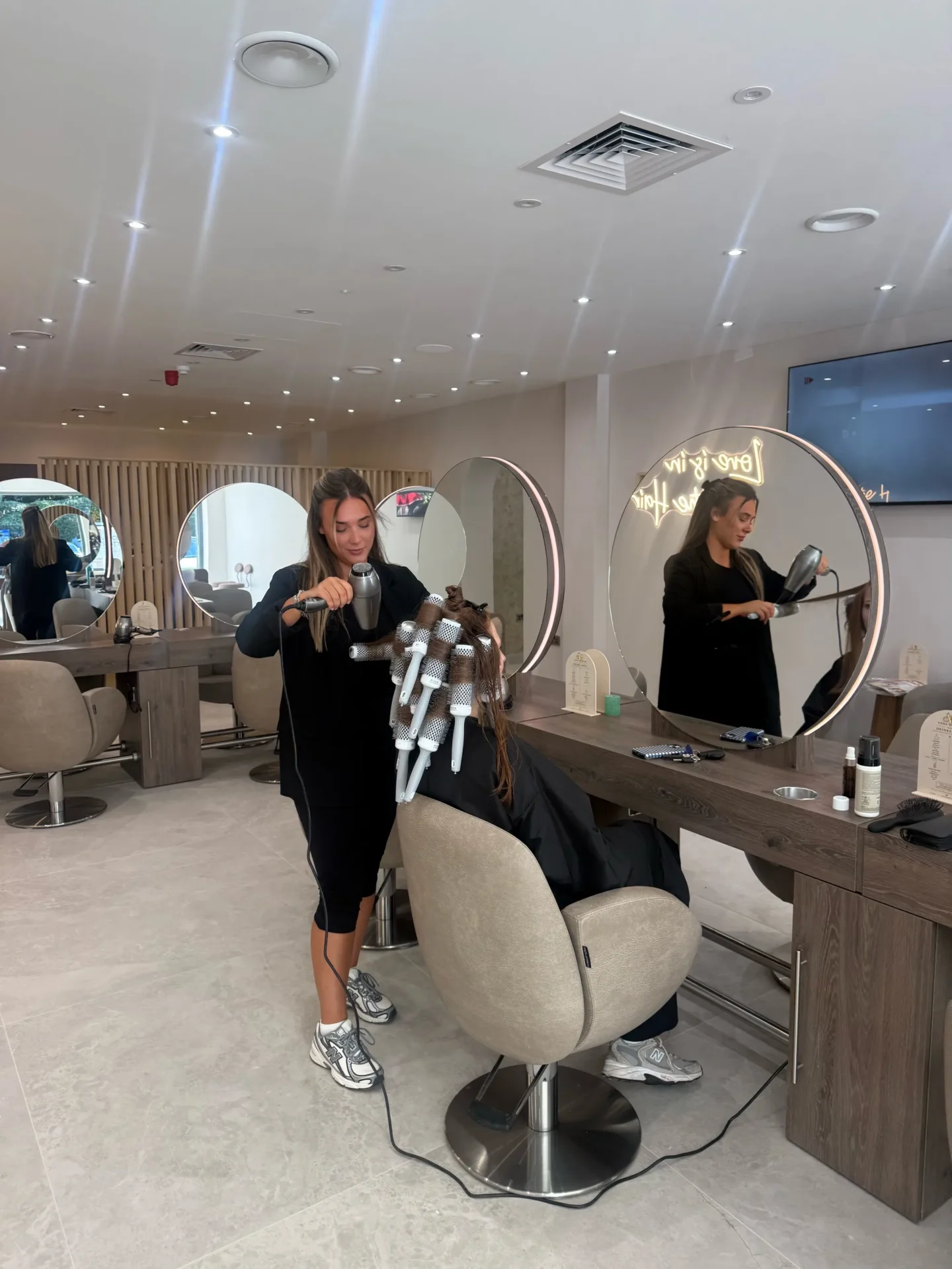 Woman sitting in a chair in front of a mirror in a salon
