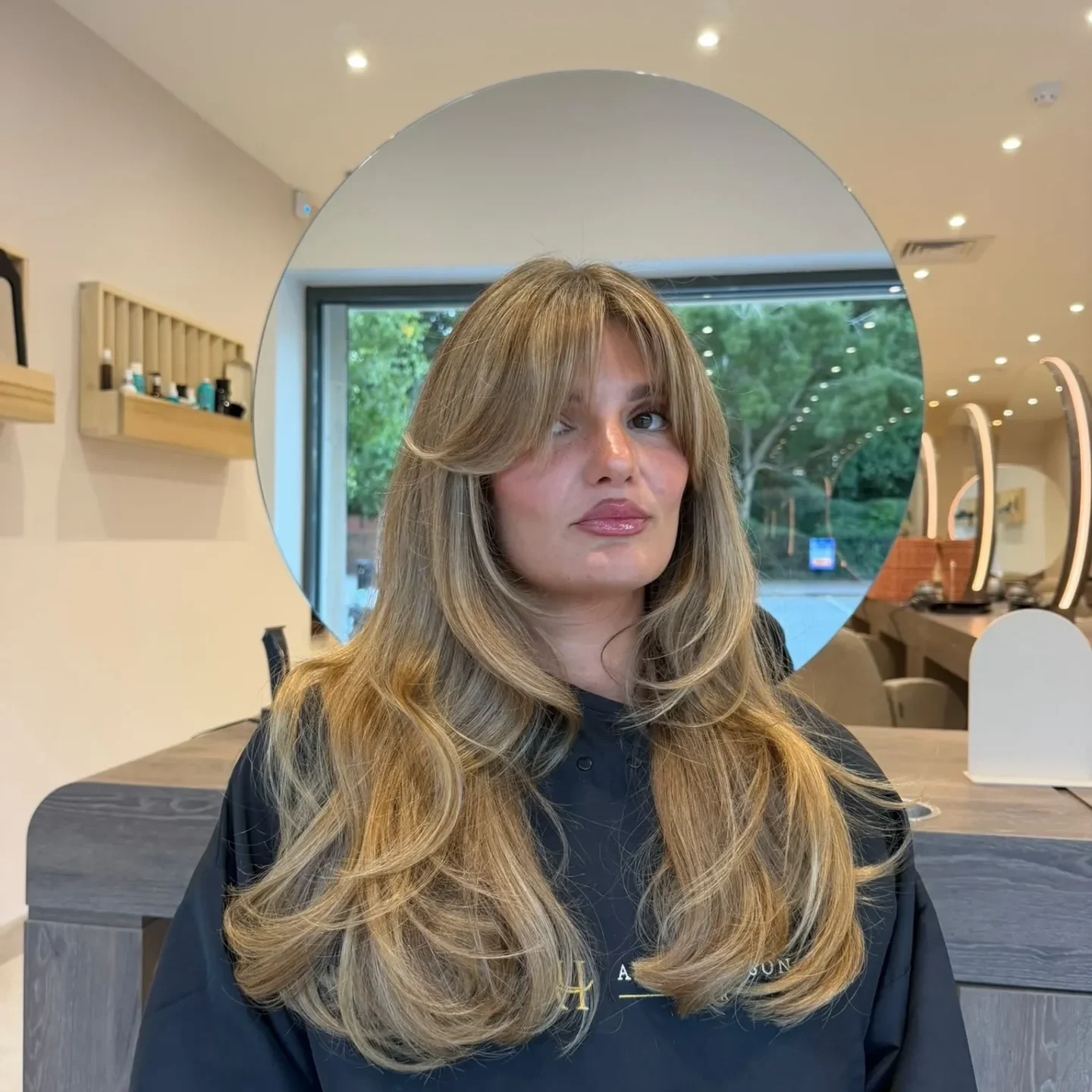 Woman sitting in a salon chair in front of a mirror